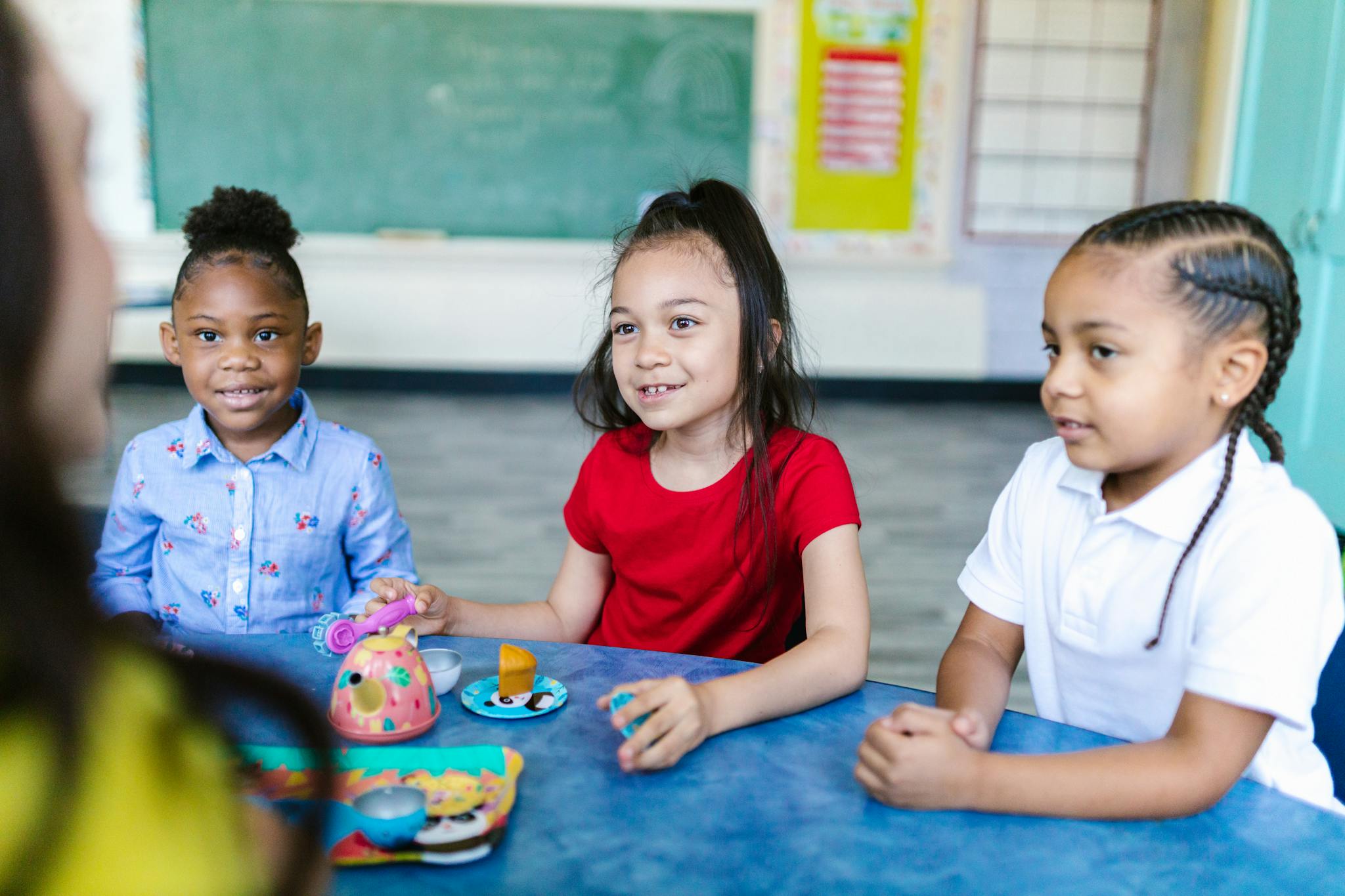 Young children enjoying a playful learning activity in a bright classroom setting.